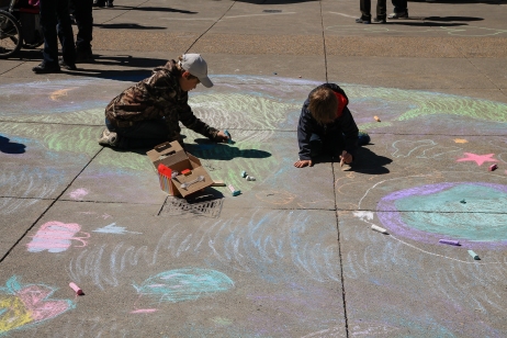 children in Calgary draw an earth on the sidewalk